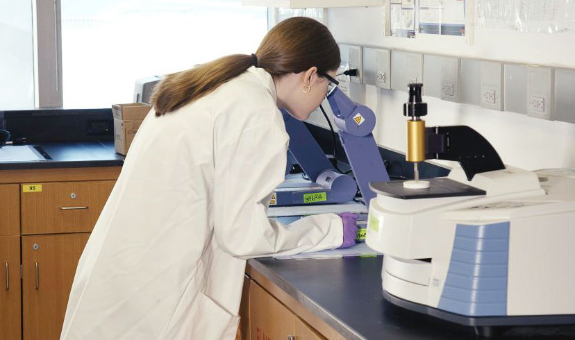 Student in a lab looking in a microscope