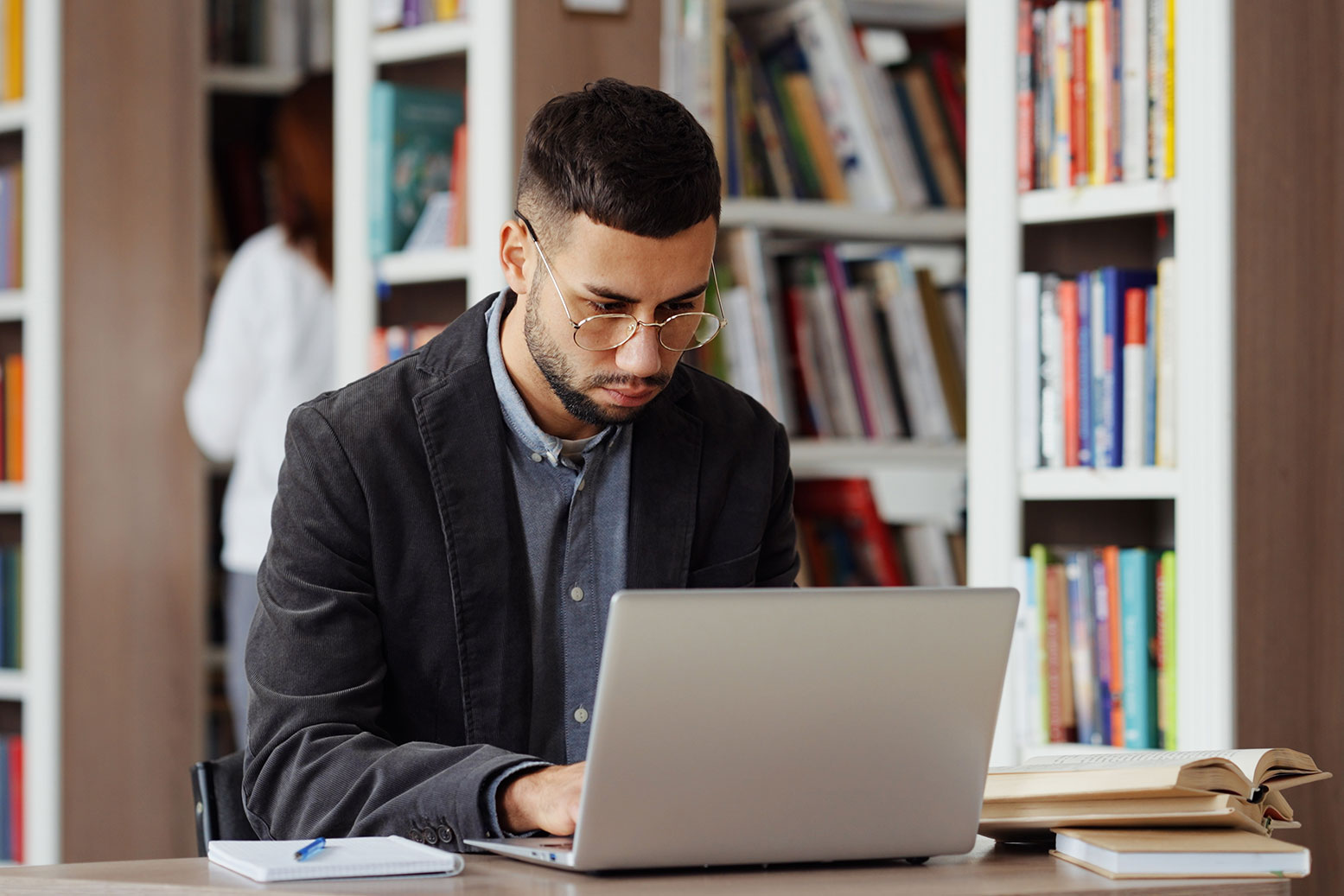 student with laptop in library