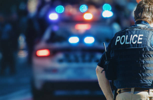 Police officer with police car in the background