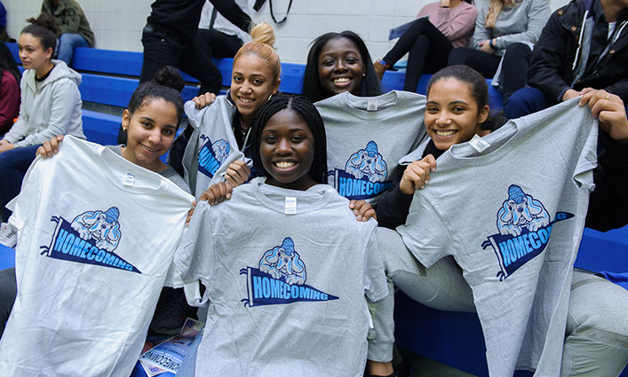 John Jay students holding up John Jay Homecoming t-shirts