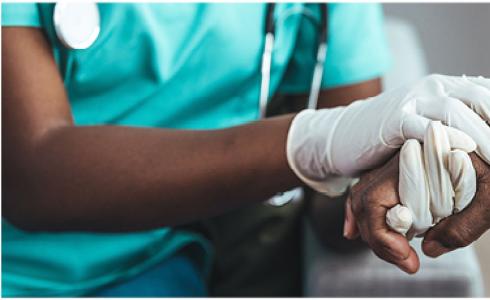 A nurse holding a patient's hand