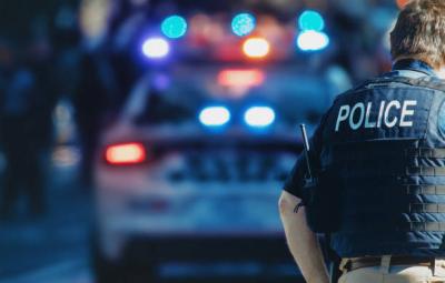 Police Officer with Patrol Car in Background